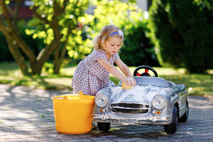 young girl cleaning toy car